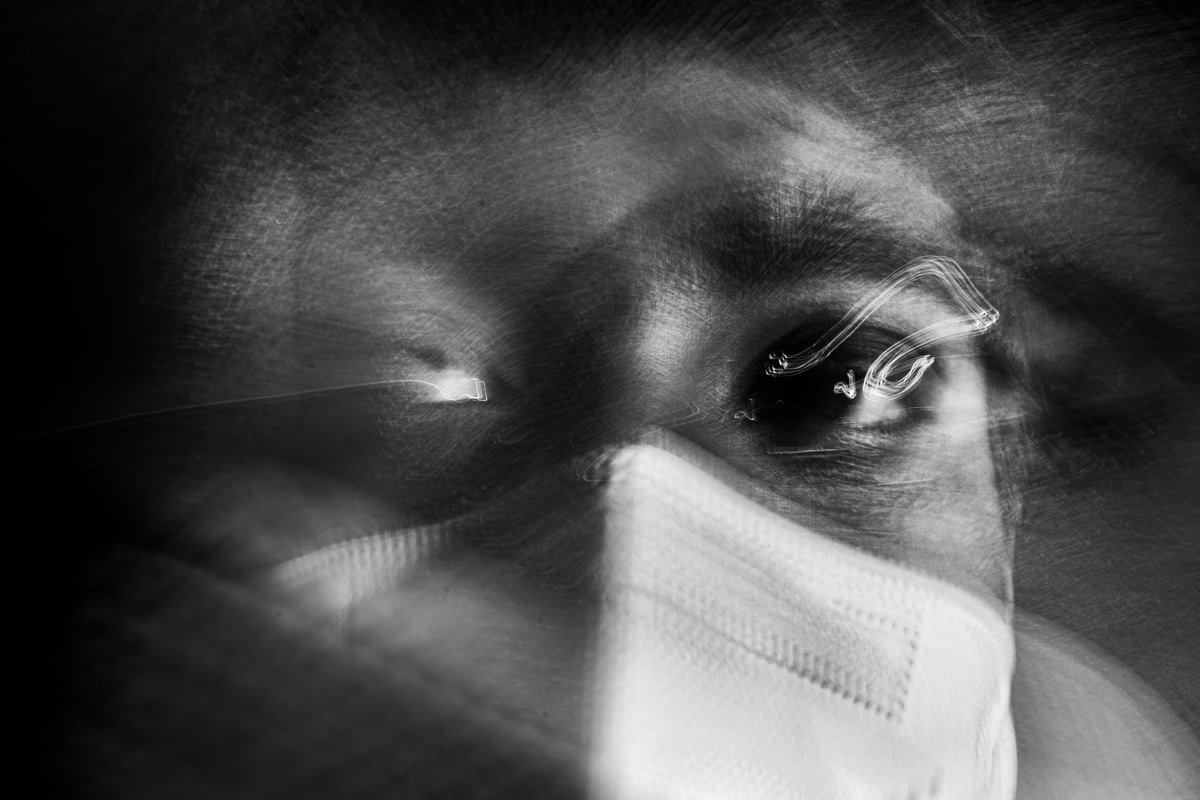 A blurred black-and-white self-portrait of Sidharth Kannan wearing a face mask.