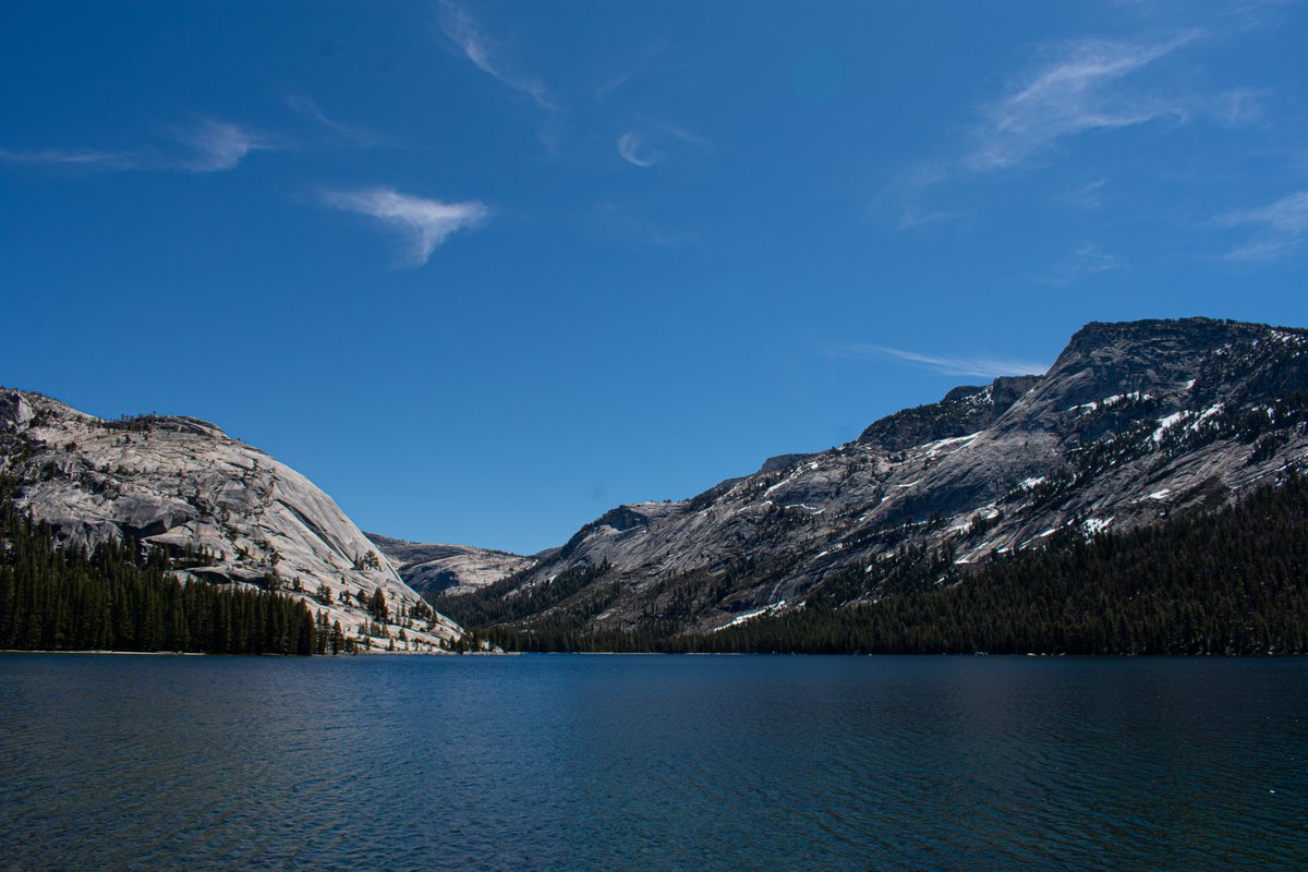 A view across Lake Tenaya toward granite slopes and evergreen trees in Yosemite.
